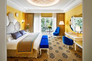 a bedroom with a king sized bed and a desk at Hotel Le Negresco in Nice