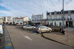 a city street with cars parked in a parking lot at La Boule d'Or in Bressuire