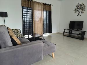 a living room with a couch and a tv at Bella - Destination Guyane in Rémire-Camp