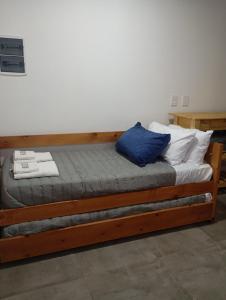 a bed with two blue pillows on top of it at YulFran in Mina Clavero