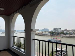 a balcony with three arches and a boat in the water at A59 Memory Hotel Tuan Chau in Ha Long