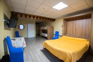 - une chambre avec un lit jaune et deux chaises bleues dans l'établissement La Boule d'Or, à Bressuire