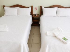 two beds in a hotel room with white sheets at Pousada Avalon - Lucena - PB in Lucena +29 photos