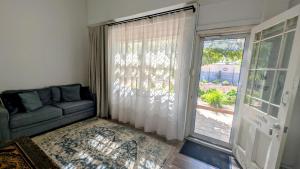 a living room with a couch and a sliding glass door at The Merredin Treasury Cottage in Merredin