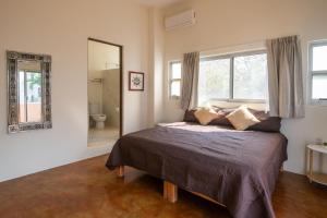 a bedroom with a large bed and a mirror at Casa Mirador 360 in Puerto Escondido