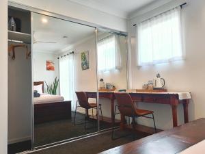 a room with a mirror and a table and chairs at Deluxe Queen Room - Shared Bathroom in Holmview