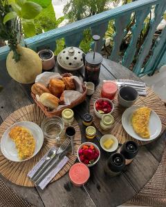a table with breakfast food on a wooden table at The Shacks at Sandy Bay in Nusa Lembongan