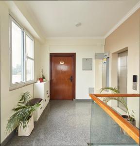 an office hallway with a wooden door and plants at Luminous Apartments & Suites in Kathmandu