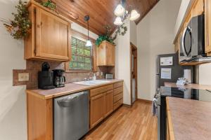 a kitchen with wooden cabinets and a stainless steel dishwasher at SBL14 -Mayberry Lodge in Branson West