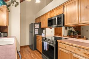 a kitchen with black appliances and wooden cabinets at SBL14 -Mayberry Lodge in Branson West +39 photos