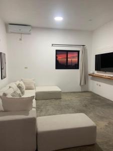 a living room with two white couches and a window at Purevibe Villa Portland Jamaica - Ocean view suite in Port Antonio