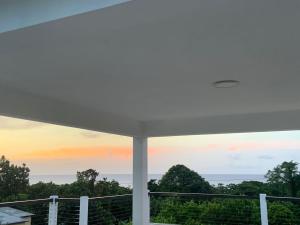 a view from the balcony of a house with a sunset at Purevibe Villa Portland Jamaica - Ocean view suite in Port Antonio