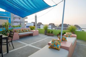 a rooftop patio with couches and a table and chairs at Casa Mirador 360 in Puerto Escondido