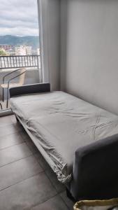 a bed sitting in a room next to a window at Depto cómodo y central in Temuco