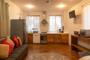 a living room with a couch and a kitchen at Casa Mirador 360 in Puerto Escondido