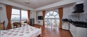 a room with a bed and a kitchen with a balcony at Luminous Apartments & Suites in Kathmandu