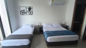 two beds in a room with a bike on the wall at Salinas del Mar Torre 4 Apt 903 - Moderno, equipado y a un suspiro del mar in Santa Marta +44 photos