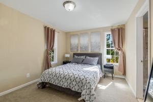 a bedroom with a bed and two windows at Stunning Entire Home in Lanham MD close to DC in Lanham