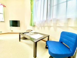 a living room with a blue chair and a table at トリトン茶屋町#101#102 in Aomori +6 photos
