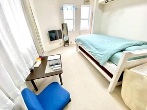 a bedroom with a bunk bed and a blue chair at トリトン茶屋町#101#102 in Aomori