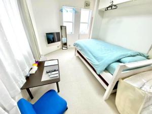 a bedroom with a bed and a table and a chair at トリトン茶屋町#101#102 in Aomori