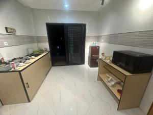 a room with a kitchen with a microwave and a door at Residence MBK Appartement A in Ziguinchor