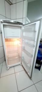 an empty refrigerator with its door open in a kitchen at Casa 3 quartos - mês com ofertas in Campo Grande