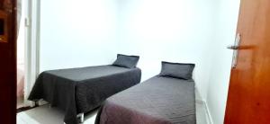 a bedroom with two beds and a window at Casa 3 quartos - mês com ofertas in Campo Grande