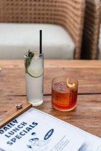 a drink sitting on a wooden table with a sign at The Shacks at Sandy Bay in Nusa Lembongan