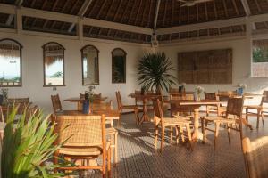 a dining room with wooden tables and chairs at The Shacks at Sandy Bay in Nusa Lembongan