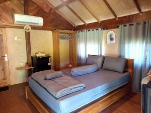 a bed with two pillows on it in a room at Cozy cove hut in Pulau Sarang +32 photos