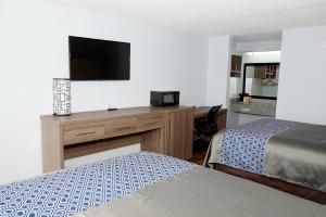 a hotel room with two beds and a flat screen tv at Legacy Inn - Gallatin in Gallatin
