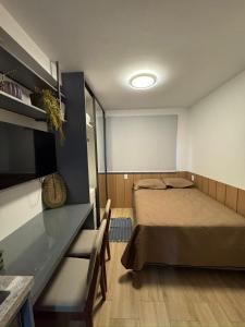 a room with a bed and a table and a television at Smart Pituba Studio Premium in Salvador +17 photos