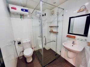 a bathroom with a shower and a toilet and a sink at Canary Boutique Hotel in Hue +43 photos