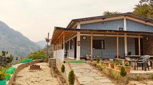 a house with a table and chairs in front of it at Ekatma Stays - Farm & Homestay, Kakrighat in Shitlakhet
