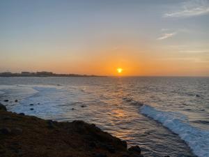a sunset over the ocean with the sun setting at Appartement Luxueux in Dakar