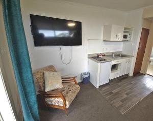 a living room with a couch and a tv on the wall at Golden Aura Suites in Stratford +18 photos