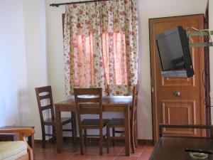 um quarto com uma mesa e cadeiras e uma televisão em Hotel-Apartamento Carolina y Vanessa em San José