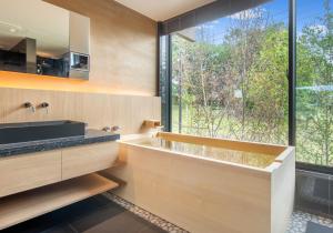 a bathroom with a tub and a large window at Shiyuki in Furano