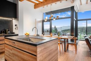 a kitchen with a sink and a large window at Shiyuki in Furano