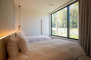 a bedroom with two beds and a large window at Shiyuki in Furano