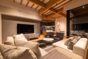 a living room with two couches and a television at Shiyuki in Furano +39 photos