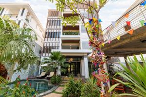 an apartment building with a swimming pool and flags at LT Angkor Hotel in Phumĭ Réach Born (2)