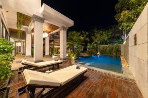a backyard with a swimming pool at night at LT Angkor Hotel in Phumĭ Réach Born (2)