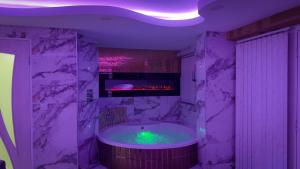 a bathroom with a large tub with a fireplace at Azura Suites in Bradford