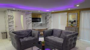 a living room with two couches and a purple ceiling at Azura Suites in Bradford