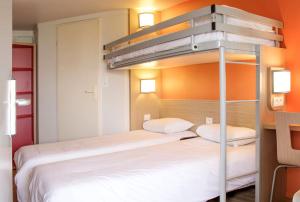 a bed room with two beds and a desk at Premiere Classe Nantes Est St Sebastien Sur Loire in Saint-Sébastien-sur-Loire