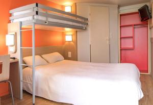 a bedroom with a bed and a dresser at Premiere Classe Nantes Est St Sebastien Sur Loire in Saint-Sébastien-sur-Loire