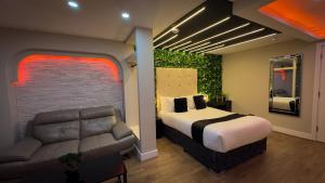 a bedroom with a bed and a couch in it at Azura Suites in Bradford
