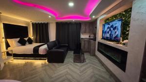 a hotel room with a bed and a flat screen tv at Azura Suites in Bradford